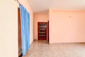 an empty room with blue curtains and a red door at HOTEL O BLISS INN GUEST HOUSE in Gorakhpur