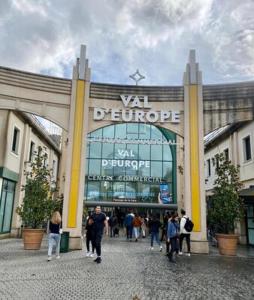 セリにあるAu pied de Disneyland Parisの建物前を歩く人々