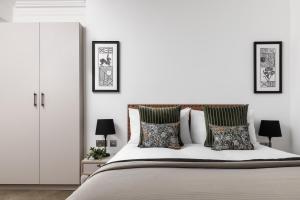 a white bedroom with a large bed with pillows at The Jubilee by Supercity Aparthotels in Leeds