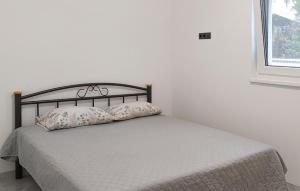 a white bedroom with a bed with two pillows at 2 Bedroom Awesome Apartment In Seline in Jurlina