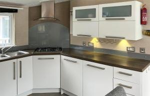 a kitchen with white cabinets and a sink at 2 Bedroom Cozy Home In Lindesnes in Spangereid +4 photos