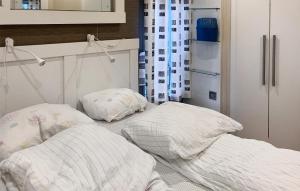 a bedroom with two beds and a refrigerator at 2 Bedroom Cozy Home In Lindesnes in Spangereid