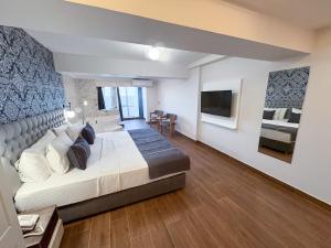 una camera da letto con un letto grande e una TV di Mira Hotel Küçükyalı a Smirne