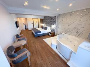 una camera d'albergo con vasca e letto di Mira Hotel Küçükyalı a Smirne