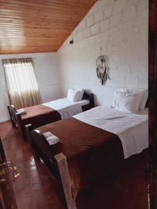 a bedroom with two beds in a room at Mahatma Experiencias que Sanan in Filandia