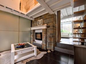 a living room with a brick fireplace and a table at Stylish Stay with Pool, Jalhay in Jalhay