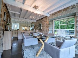 a dining room with a stone wall and a table and chairs at Stylish Stay with Pool, Jalhay in Jalhay