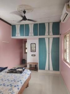 Un dormitorio con una cama y un ventilador de techo. en Tanvi Guest House Hampi, en Hampi
