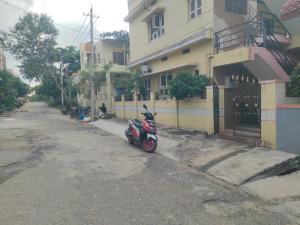 un scooter estacionado en el lateral de un edificio en Tanvi Guest House Hampi, en Hampi 5 fotos más