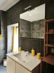 une salle de bain avec un lavabo et un miroir dans l'établissement Gîte du Feuil, à Blassac