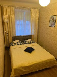 een slaapkamer met een bed met een geel dekbed en een raam bij Imantas in Daugavpils