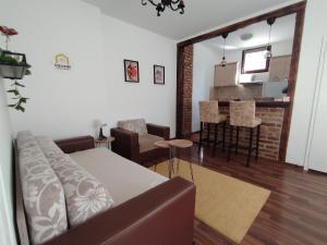 a living room with a couch and a kitchen at SQUARE apartment in Ćuprija