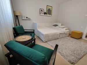 a small bedroom with a bed and a chair at SQUARE apartment in Ćuprija