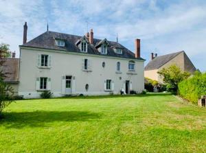 a large white house with a large yard at Gite d'Oliva in Suèvres