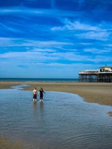 two people walking in the water on the beach at Cala Gran Holiday Park - Holiday Accommodation 10830 in Fleetwood