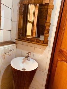 a bathroom with a sink and a mirror at Bugoma Palms Resort Sand Beach 