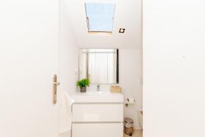 a white bathroom with a sink and a window at New Amazing Cozy House in the heart Lisbon in Lisbon +107 photos