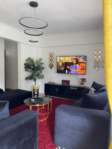 a living room with a couch and a tv at New Haven 3 in Kisii +4 photos
