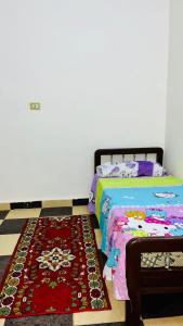 a bedroom with a bed and a rug at Jordan house in Al Bāriḩah