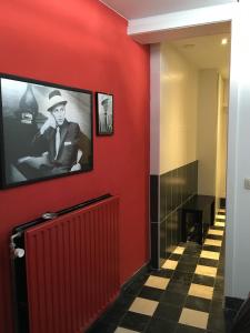 a hallway with a red wall with a picture of a man at Le Grand Cabaret in Nieuwpoort