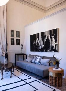 a living room with a couch and a picture on the wall at Palazzo Giacometti Suites in Piacenza +21 photos