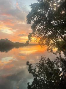 a body of water with a sunset in the background at LAKE LOFT - La maison VEDA in Koggala
