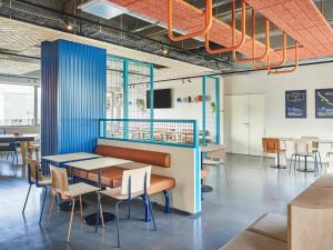 Un restaurante con mesas y sillas en una habitación. en ibis budget Nancy Laxou, en Nancy