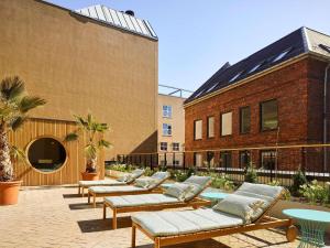 a row of benches in a courtyard next to a building at 25hours Hotel Indre By in Copenhagen