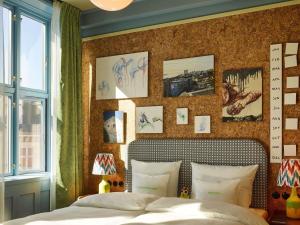 a bedroom with a bed and some pictures on the wall at 25hours Hotel Indre By in Copenhagen +53 photos