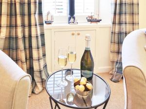 a glass table with two glasses of wine and bread at Union Street in Kirkcudbright