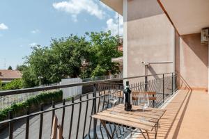 a balcony with a wooden table and wine glasses at GuestHost - Trecastagni Elegant & Comfy Apartment in Trecastagni
