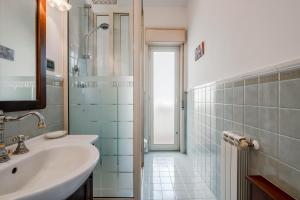a white bathroom with a sink and a shower at GuestHost - Trecastagni Elegant & Comfy Apartment in Trecastagni +17 photos