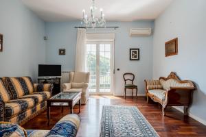 a living room with a couch and chairs and a tv at GuestHost - Trecastagni Elegant & Comfy Apartment in Trecastagni