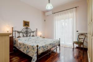 a bedroom with a bed and a chair and a window at GuestHost - Trecastagni Elegant & Comfy Apartment in Trecastagni