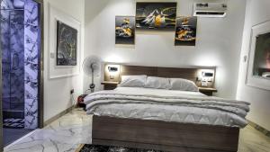 a bedroom with a large bed and some pictures on the wall at Jayhaven Crystal Serviced Apartment in Uyo