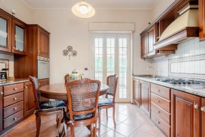 a kitchen with a wooden table and chairs at GuestHost - Trecastagni Elegant & Comfy Apartment in Trecastagni