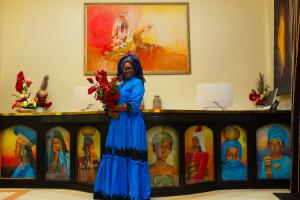 a woman standing in front of a group of statues at Hôtel La Villa Racine in Dakar