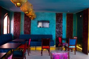 a restaurant with tables and chairs and a blue wall at Hôtel La Villa Racine in Dakar