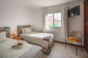 a small room with two beds and a window at VILLA ALAY by Buenavilla in Playa Blanca +24 photos