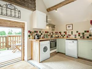 a kitchen with a washer and dryer at The West Barn in Hanley Castle