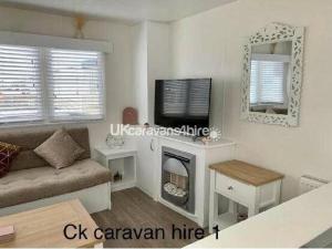 a living room with a couch and a tv at Golden Gate Holiday Centre - Holiday Accommodation 19058 in Kinmel Bay