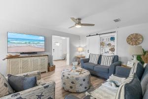 a living room with couches and a flat screen tv at Casa del Limone in Chicken Island