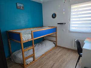 Ce lit superposé se trouve dans un dortoir doté d'un mur bleu. dans l'établissement Ti Goéland 4 chambres Proche Mont St Michel, à Roz-sur-Couesnon