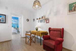 a living room with a red chair and a table at Casa Alma in Isla Cristina