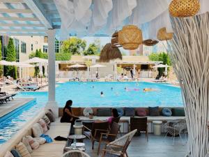 a swimming pool with two people sitting on a couch in front of it at Hotel Misto SPA & FITNESS in Kharkiv