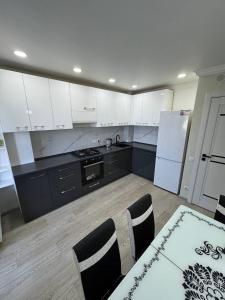 a kitchen with white cabinets and a white refrigerator at Panorama view apartament tolstoi str in Chişinău