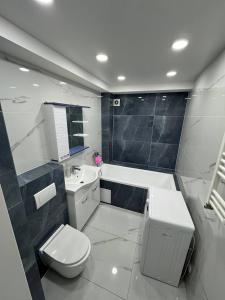 a bathroom with a toilet and a tub and a sink at Panorama view apartament tolstoi str in Chişinău