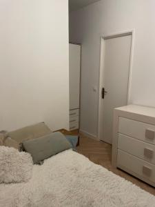 a bedroom with a bed and a dresser and a door at Le Cocon de la Maison des Chefs in Veynes