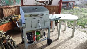 a grill and a table next to a table at Caravan in the backyard in Šaľa