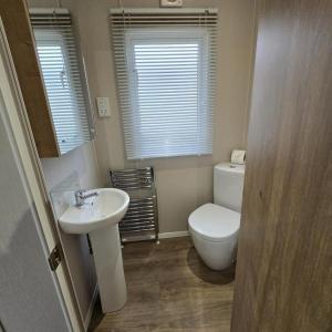a bathroom with a white toilet and a sink at Thornwick Bay Holiday Village - Holiday Accommodation 20633 in Flamborough